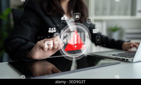 Red warning triangle representing a cybersecurity threat or data breach alert, surrounded by digital security and network protection icons Stock Photo