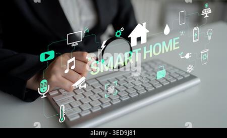 Person interacts with smart home technology using keyboard and touchscreen devices showing modern digital home automation concepts and applications Stock Photo