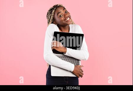 Technology Lover. Excite black woman hugging personal computer Stock Photo