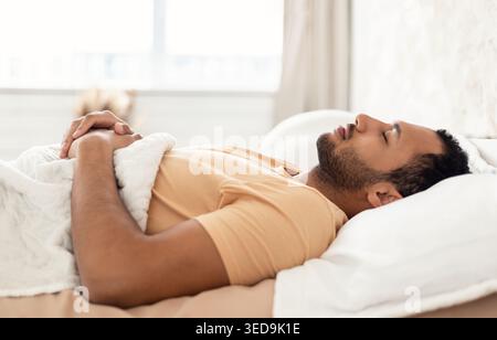 Arabic Young Man Sleeping Lying On Back Resting In Bedroom Stock Photo