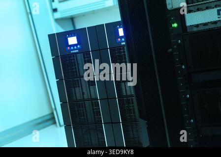 This image showcases a modern server room featuring high-tech equipment, illuminated by blue LED lights, representing cutting-edge technology and data Stock Photo