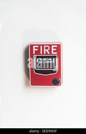 A close-up view of a red fire alarm button mounted on a wall, emphasizing safety and emergency preparedness in various environments. Stock Photo