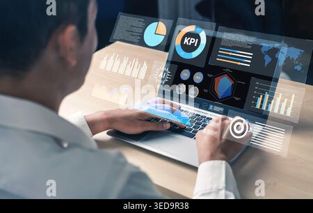 A business professional focuses on a futuristic laptop displaying holographic graphs and charts, illustrating key performance indicators for strategic Stock Photo
