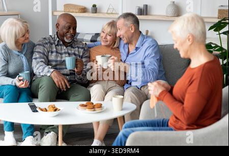 Positive multiracial senior people spending time together at retirement house Stock Photo