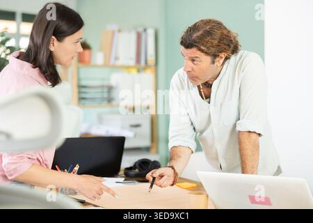 Two architects discuss a building plan in company office Stock Photo
