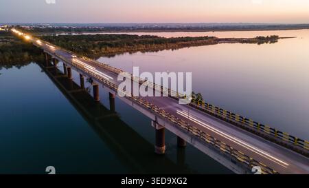 Aerial view of the Jhelum bridge spanning the river with car light trails during sunset Jhelum, Punjab, Pakistan. Stock Photo