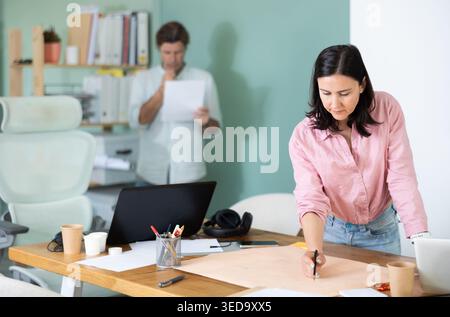 Two architects discuss a building plan in company office Stock Photo