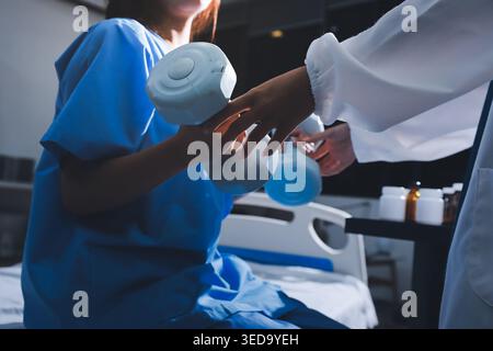 Physical therapist assisting a woman with dumbbell exercise Stock Photo
