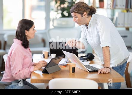 Man and female colleagues discussing project together Stock Photo
