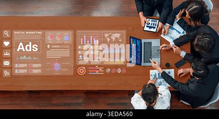 A diverse team of professionals collaborates in a modern office setting, utilizing technology and analytics to strategize effective digital marketing Stock Photo