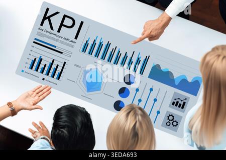 A top-down view of a professional team analyzing a KPI dashboard with various charts and graphs, perfect for showcasing business performance metrics Stock Photo
