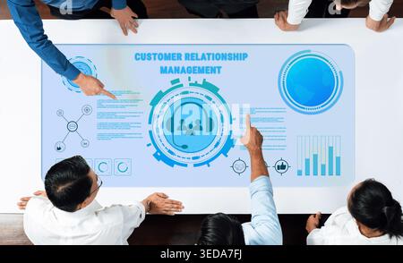 A collaborative business meeting focused on customer relationship management featuring modern technology and data visualization, enhancing teamwork Stock Photo