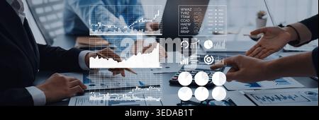A business meeting scene showing professionals analyzing financial data. The image features charts and digital analytics, capturing teamwork in a Stock Photo
