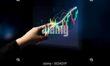 A business professional uses a touchscreen display to analyze financial data and stock market trends. The hand points at vibrant graphs indicating Stock Photo