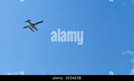 Sitka, USA - August 3 2024: Floatplane flying above Sitka Pioneers Home in Sitka, Alaska. The floatplane is against a clear blue sky with few clouds. Stock Photo