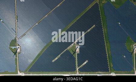 Aerial view of Chelveston Wind Farm showing rows of solar panels and wind turbines integrated into the landscape Wellingborough, England, United Kingd Stock Photo