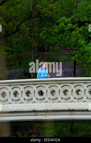 Women in blue jersey standing on a bridge in Central Park. Stock Photo