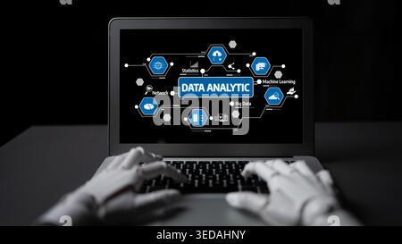 A futuristic view of a robotic hand interacting with a laptop screen that showcases various data analytics concepts, emphasizing innovation in Stock Photo