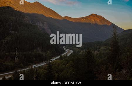Winding Highway Passing Through a Deep Mountain Valley at Golden Hour in the Cascade Range Stock Photo