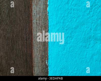 Vertical split composition featuring dark weathered wood planks on the left and a teal textured wall on the right. Stock Photo
