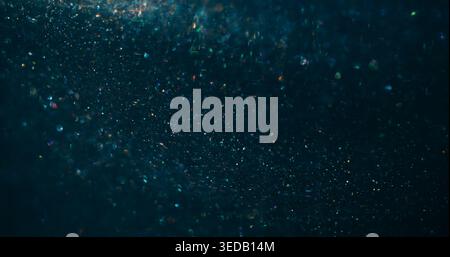 Twinkle bokeh confetti. Flare glimmer. Gradient color mixing light flow. Shimmering blur particles spill on blue black abstract background. Stock Photo
