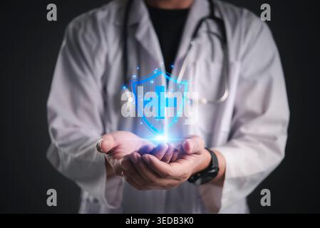 Doctor hand holding virtual blue shield protection with medical cross. Healthcare insurance, safety security, and virus defense concept. Future medica Stock Photo