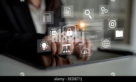 A business professional interacts with a digital tablet, showcasing various interface icons and emphasizing themes of cybersecurity and modern Stock Photo
