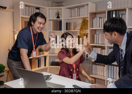 Business team discussing project together in office, sharing ideas and reviewing data on tablet and documents, representing collaboration, communicati Stock Photo