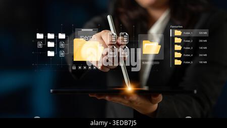 A businessperson interacts with a digital tablet, organizing virtual files and folders using a touchscreen pen, representing modern office technology Stock Photo