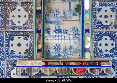 Close-up view of an ornate interior wall featuring traditional blue and white ceramic tiles with intricate floral patterns and mirrored glass inlays. Stock Photo