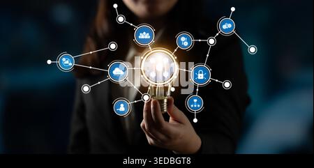 This image features a business professional holding a light bulb with connected symbols, representing ideas, technology, and innovation in a modern Stock Photo