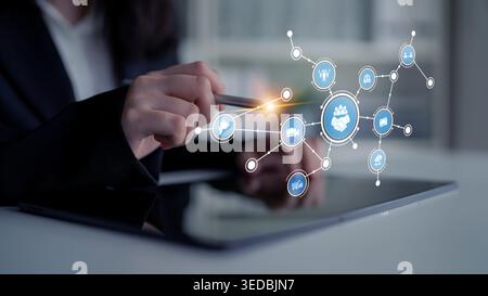 A professional businesswoman interacts with a tablet, showcasing a vibrant digital network of icons that symbolize technology and connectivity in a Stock Photo