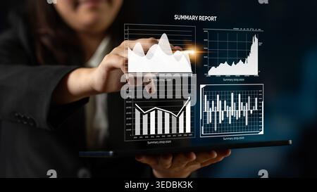 A focused businesswoman interacts with digital summary reports displaying various graphs and charts, showcasing financial data analysis and trends for Stock Photo
