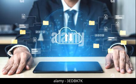 A businessman in formal attire interacts with a digital cloud interface, symbolizing data transfer and connectivity in the contemporary office Stock Photo