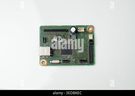Circuit board with an integrated circuit, USB connector, capacitors and pin headers photographed on a white background. Ideal for technology, electron Stock Photo