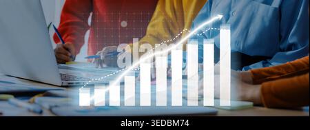 A business team collaborates in a workspace, analyzing performance metrics and visualizing data on a laptop to develop growth strategies and enhance Stock Photo