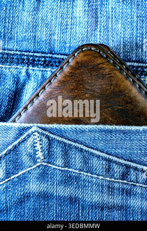 Close-up of a brown leather wallet placed in a back jeans pocket. Everyday lifestyle concept showing personal belongings, casual style, and daily rout Stock Photo