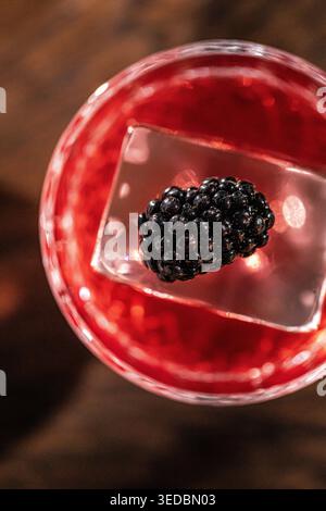 Red cocktail with blackberry on ice cube Stock Photo