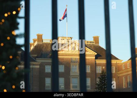 Apeldoorn ' Loo historic royal palace glows under warm, late afternoon sun. A festive Christmas tree stands near the facade, while holiday lights twin Stock Photo
