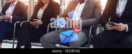 A group of professionals engages with their smartphones while waiting in a sleek office lobby, with animated notification graphics illustrating modern Stock Photo