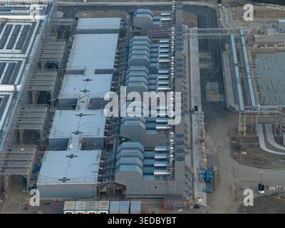 Aerial view of a hyperscale data center facility featuring rows of cooling units and industrial infrastructure. Stock Photo
