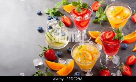 Assortment summer non-alcoholic cocktails with fresh berries, herbs and fruits on dark background. Stock Photo