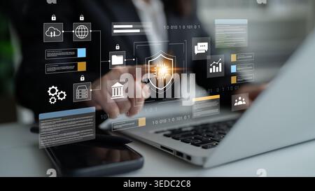 A professional engages with a digital security interface on a laptop. Visual elements illustrate cybersecurity themes, data protection, and cloud Stock Photo