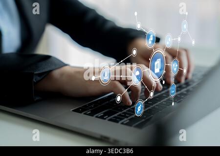 A close-up view of hands typing on a laptop, surrounded by digital icons representing connections and data, showcasing technology in a business Stock Photo