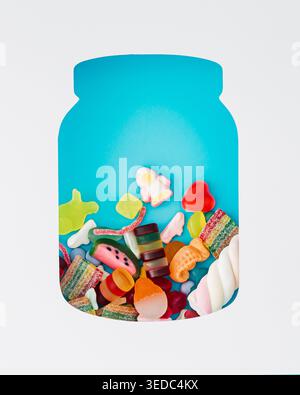 Colorful gummy candies inside jar shape cutout on light blue background. Trendy gummies concept. Jelly sweets aesthetic. Creative flat lay background. Stock Photo