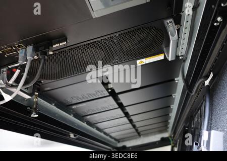 This image showcases the interior of a modern data center server rack, highlighting advanced cooling systems, organized cabling, and essential hardwar Stock Photo