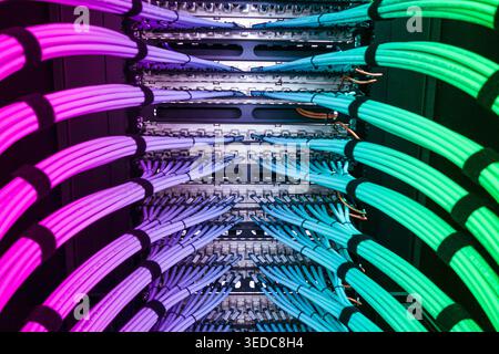 Vibrant network cables arranged in a server rack create a captivating visual. Ideal for showcasing technology, data management, and modern infrastruct Stock Photo