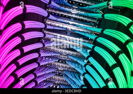 A close-up view of vibrant data cables arranged in a server rack. The colorful cables highlight the complexity of modern network installation and conn Stock Photo