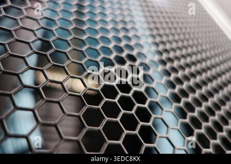 Close-up image showcasing a hexagonal metal mesh displaying intricate patterns and textures, ideal for industrial and architectural design projects. Stock Photo