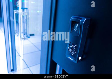 A close-up view of a high-tech access control system featuring a fingerprint scanner and keypad. This futuristic device enhances security in modern fa Stock Photo